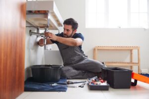 Person under a sink fixing pipes