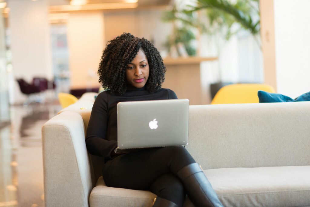 Person sitting on a couch using a laptop